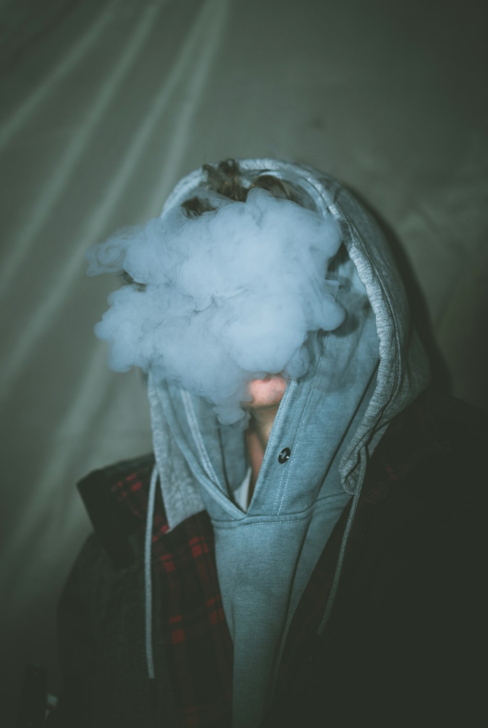 a person wearing a hoodie with a cloud of smoke coming out of it