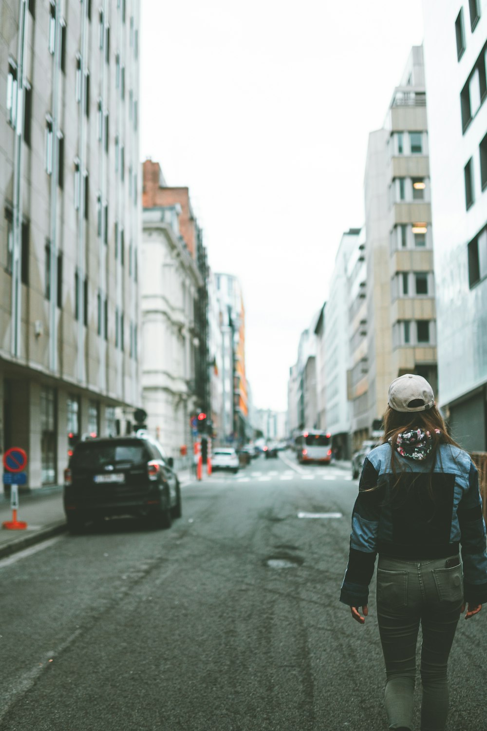 a woman walking down a street in a city