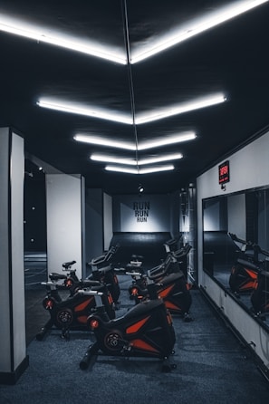 a gym with a row of stationary exercise bikes