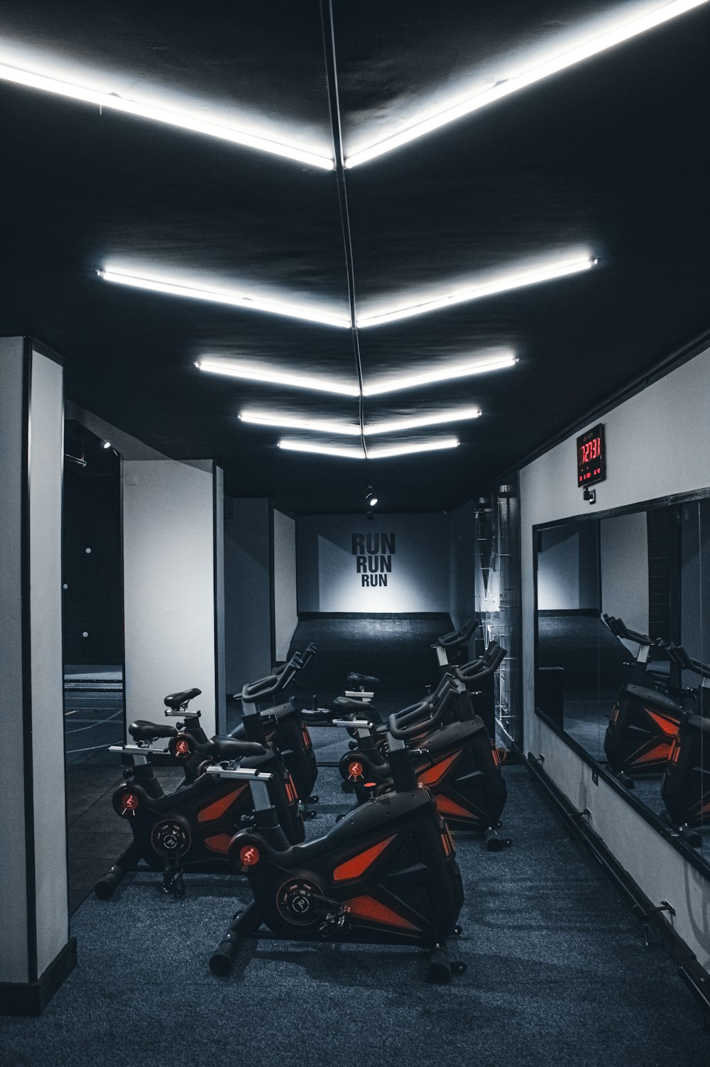 a gym with a row of stationary exercise bikes