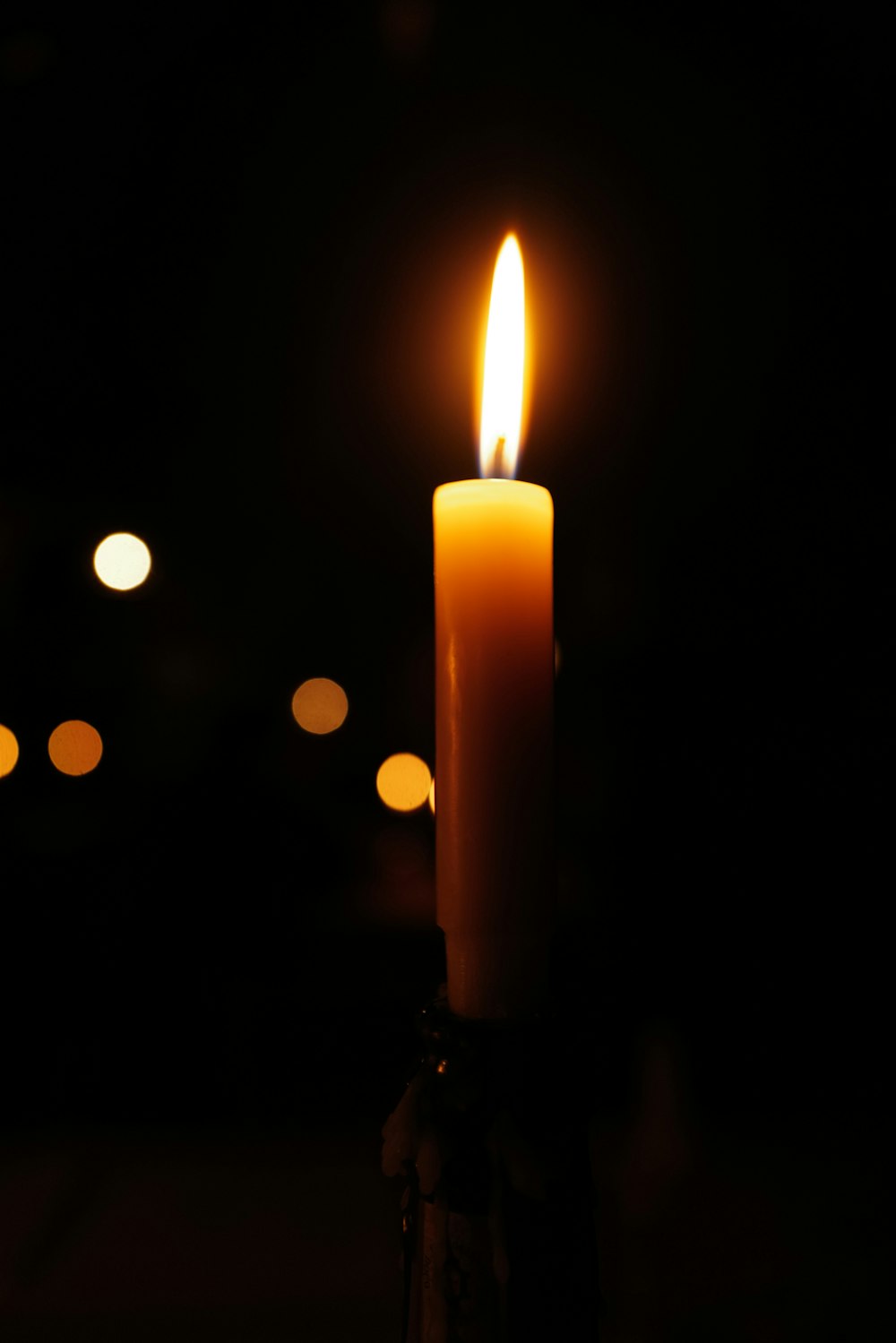 a lit candle in a dark room