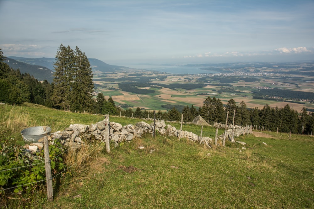 a stone wall on a hill with a view of a valley
