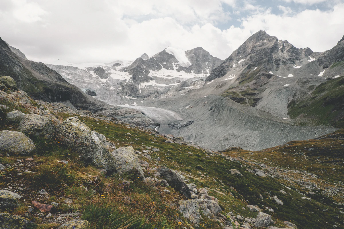The Zinal Glacier and the peaks above it under cloud, with a rocky slope in front