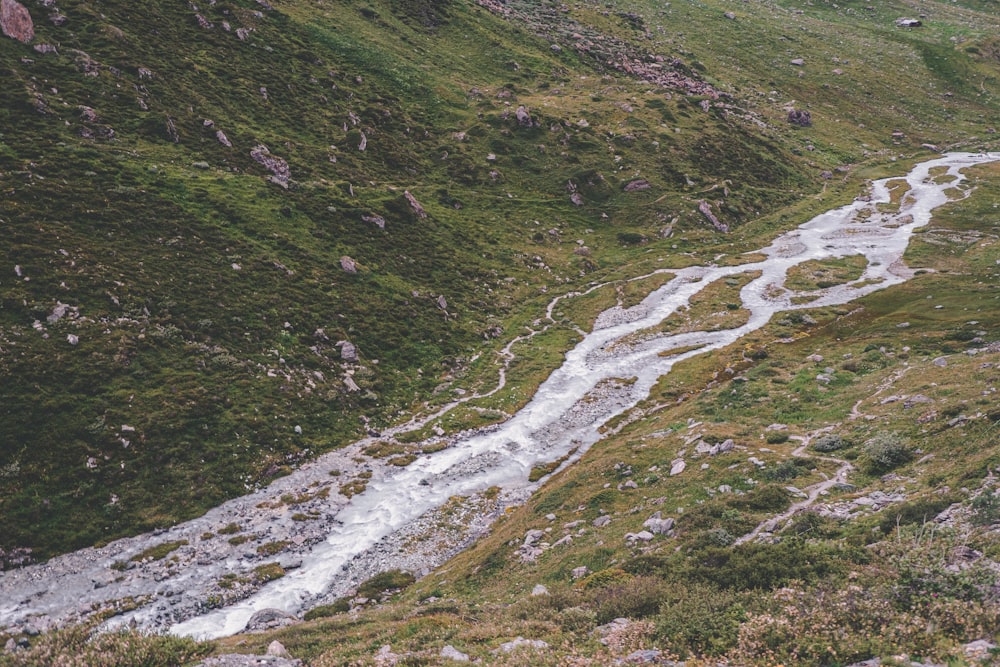 a river running through a lush green hillside