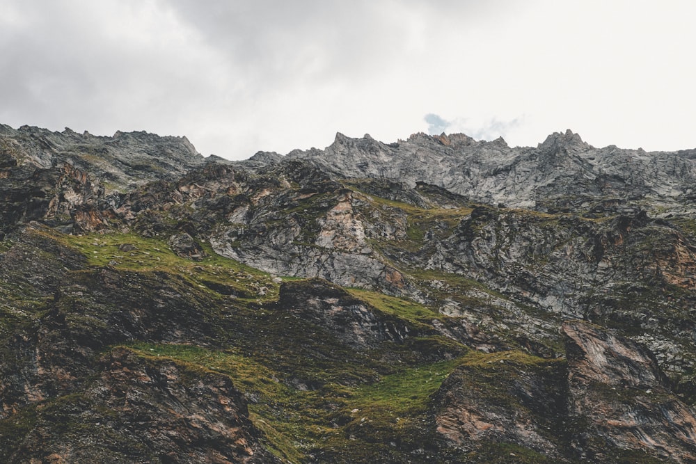 a very tall mountain covered in lots of green grass