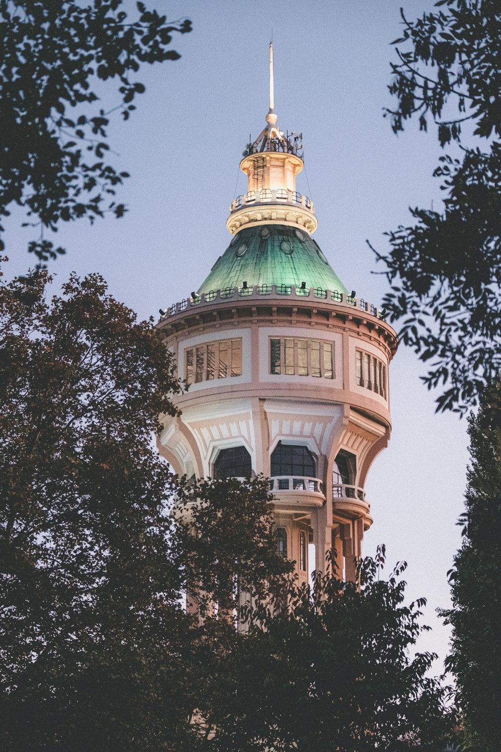 a tall building with a green dome and a clock