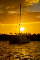 a sailboat in a body of water at sunset