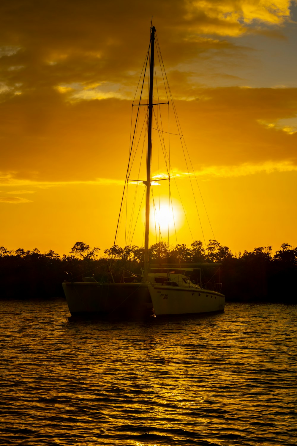 a sailboat in a body of water at sunset