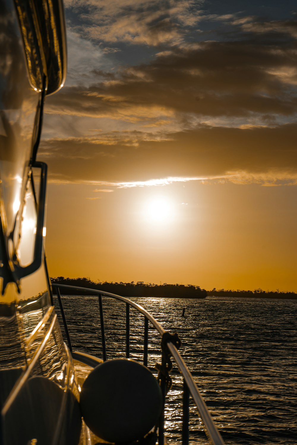 the sun is setting over the water on a boat