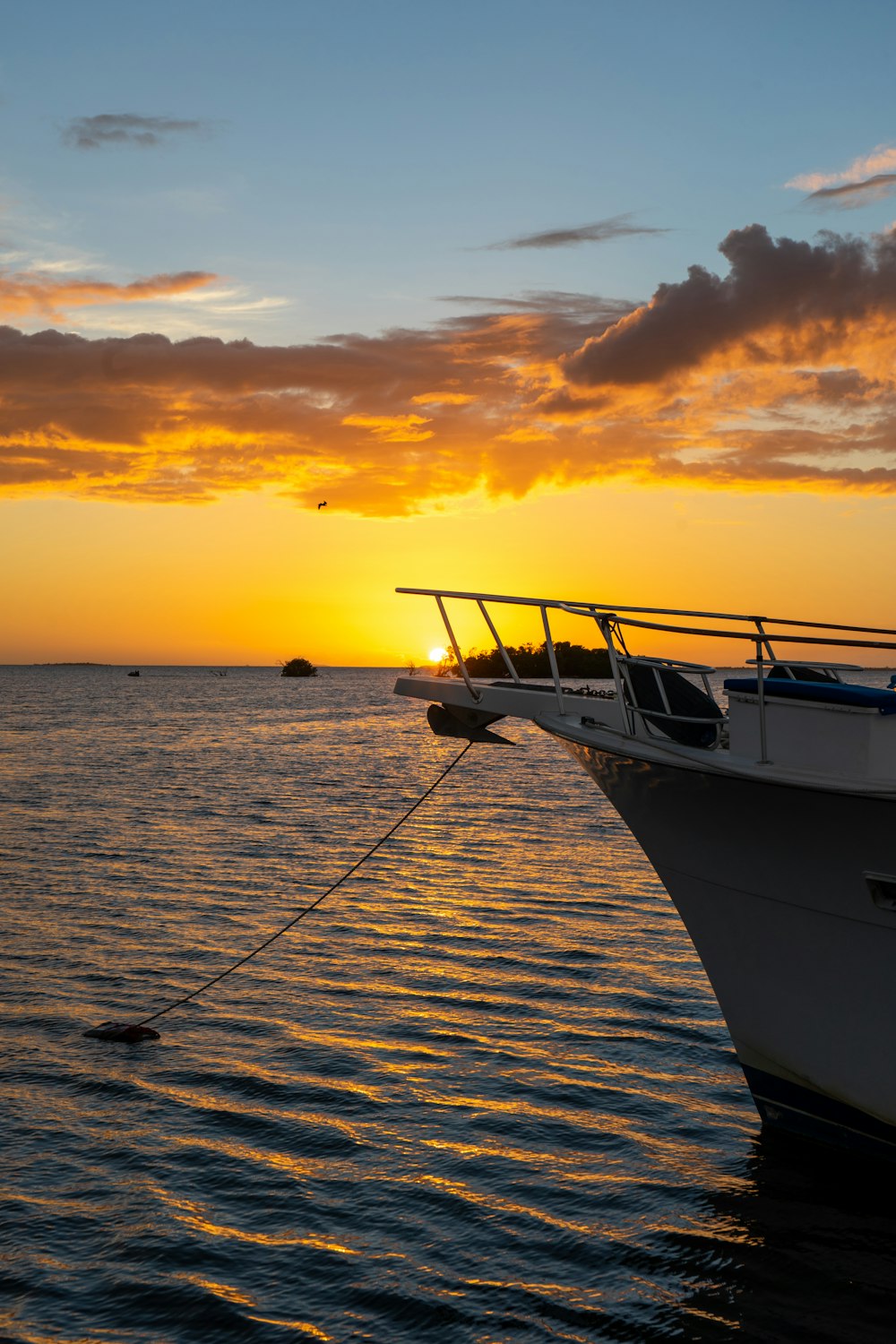 a boat in the water with the sun setting in the background