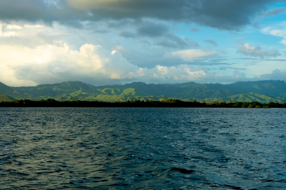 a body of water with mountains in the background