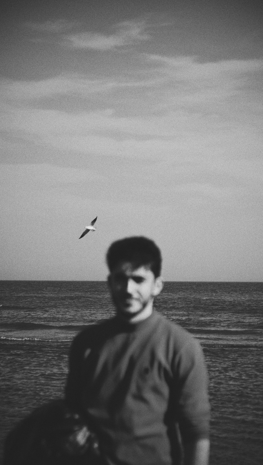 a man standing on a beach next to the ocean