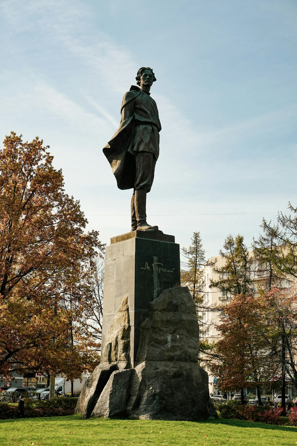 a statue of a man standing on top of a green field