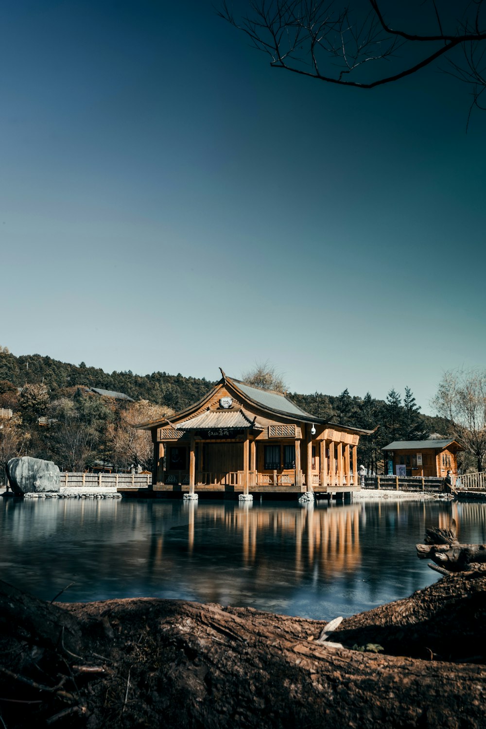 a building sitting on top of a lake next to a forest