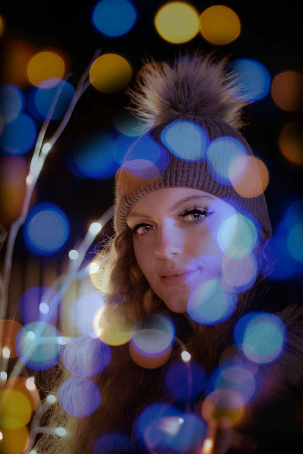 a woman wearing a hat and a fur pom - pom