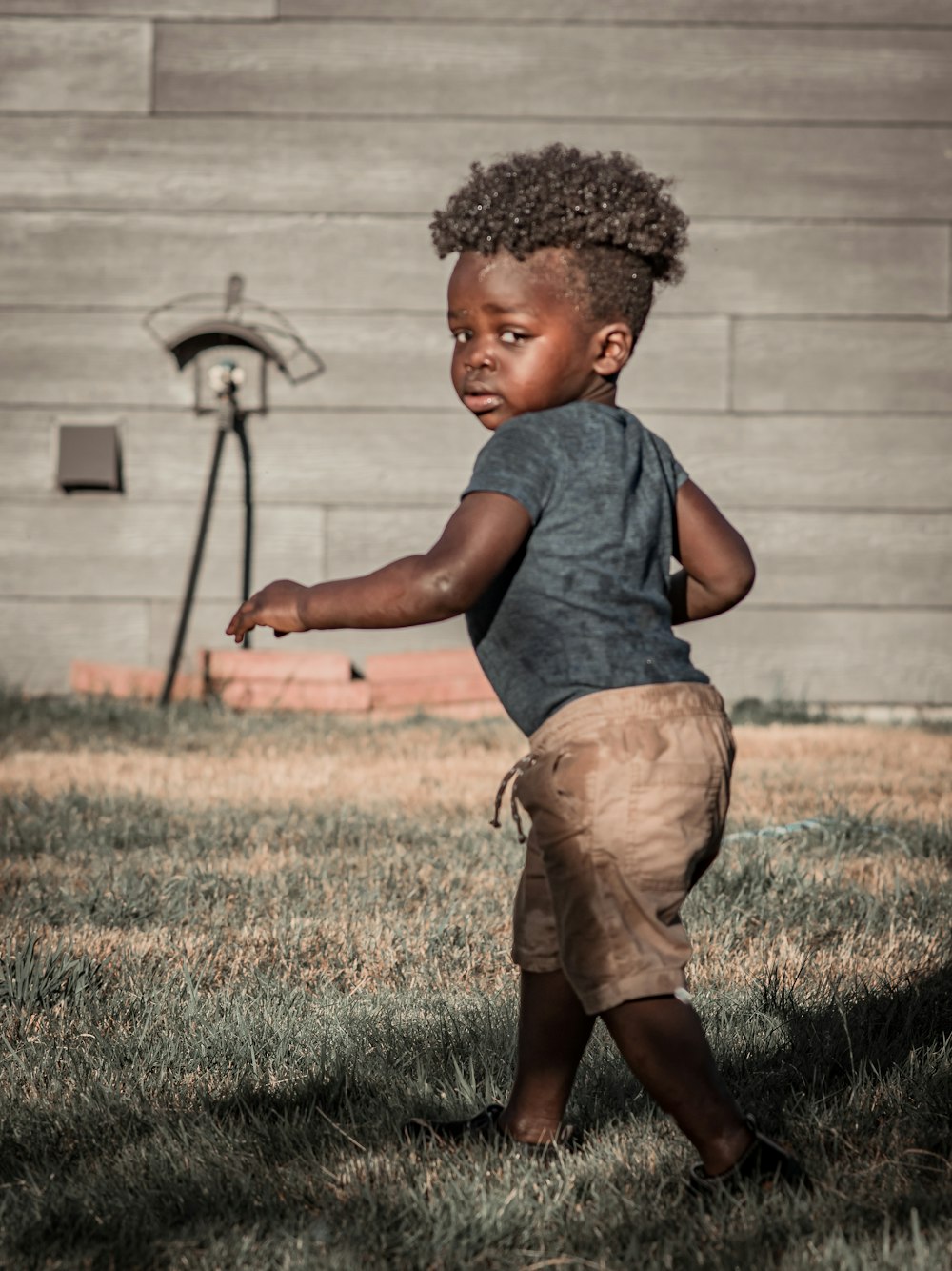 a little boy that is standing in the grass