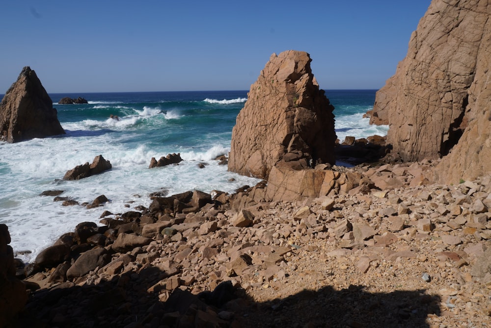 a rocky beach with waves crashing against the rocks