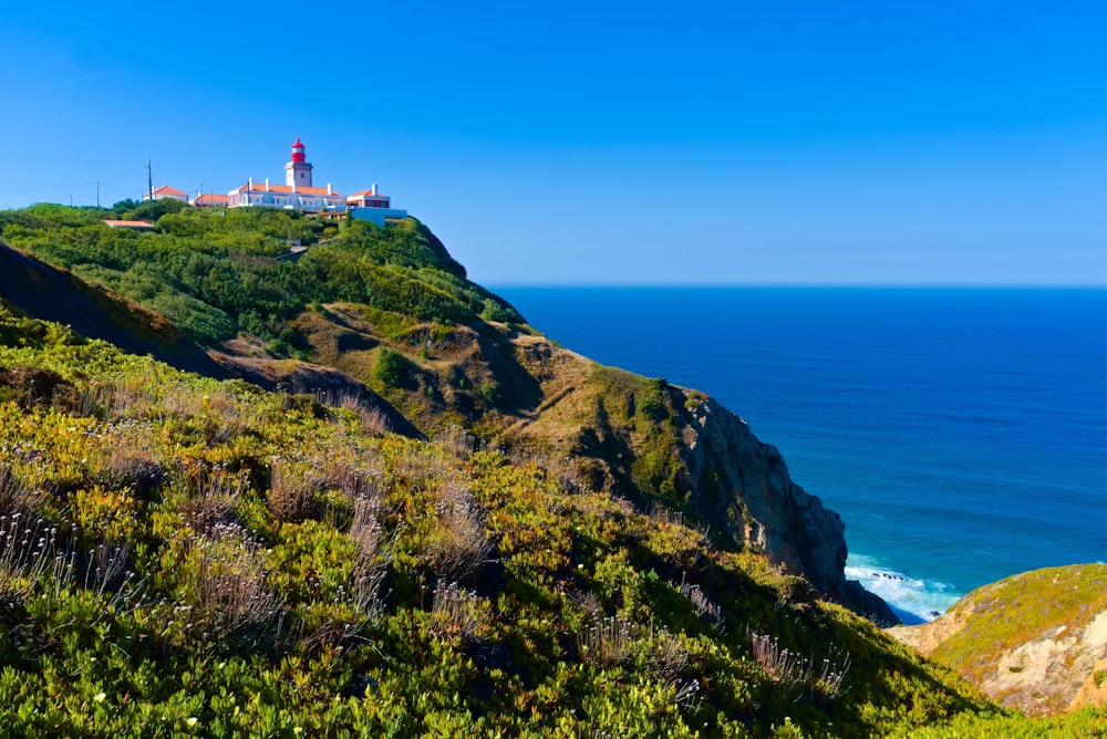 a lighthouse on a hill overlooking the ocean