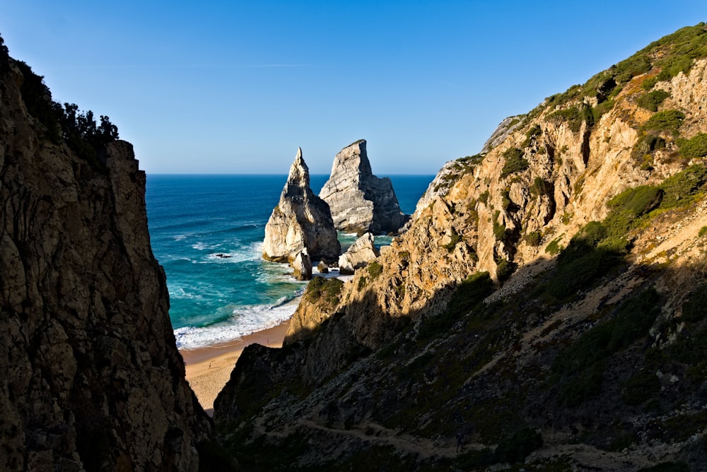 a rocky cliff overlooks the ocean and beach