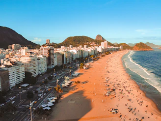 an aerial view of a beach with a city in the background