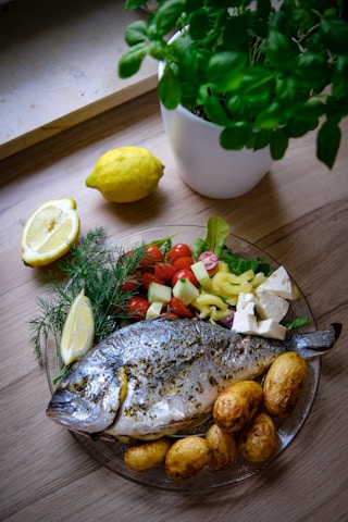 A platter of fresh grilled fish and shrimp served with lemon and herbs.