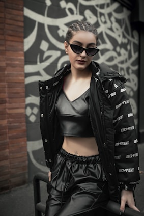 a woman in a black jacket and leather pants