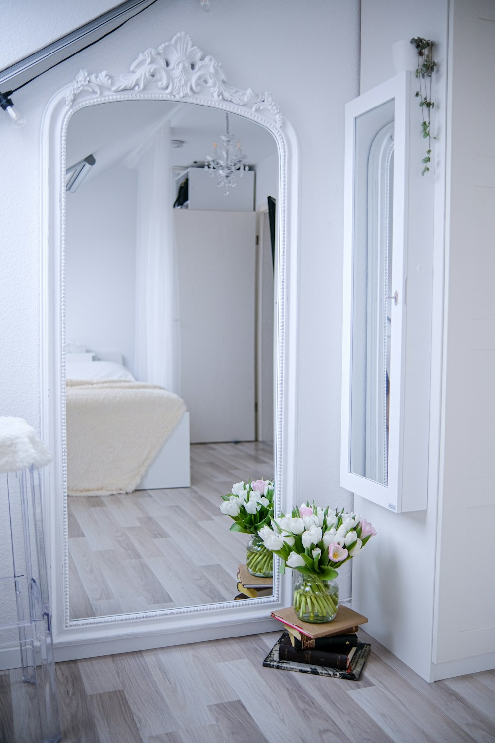 a large white mirror sitting on top of a wooden floor