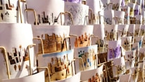 A collection of artistic prints, each depicting scenes of traditional village life, featuring desert landscapes, buildings, and people. They are arranged in an overlapping manner on display, with different color schemes and intricate designs visible.