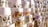 A collection of artistic prints, each depicting scenes of traditional village life, featuring desert landscapes, buildings, and people. They are arranged in an overlapping manner on display, with different color schemes and intricate designs visible.