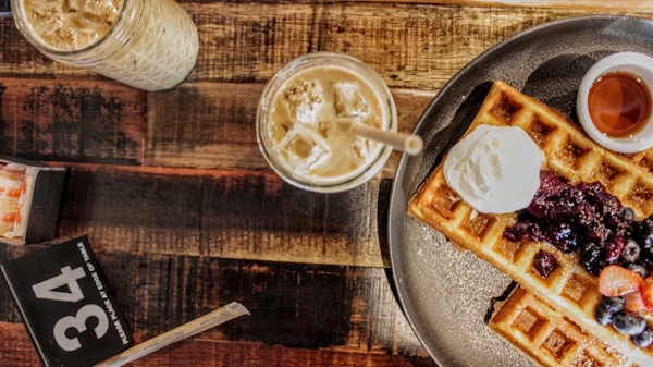A plate of waffles with fruit and ice cream