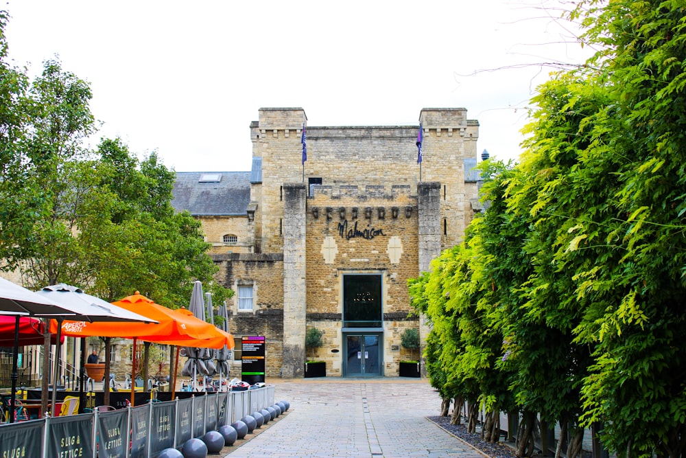 a brick building with an orange umbrella in front of it