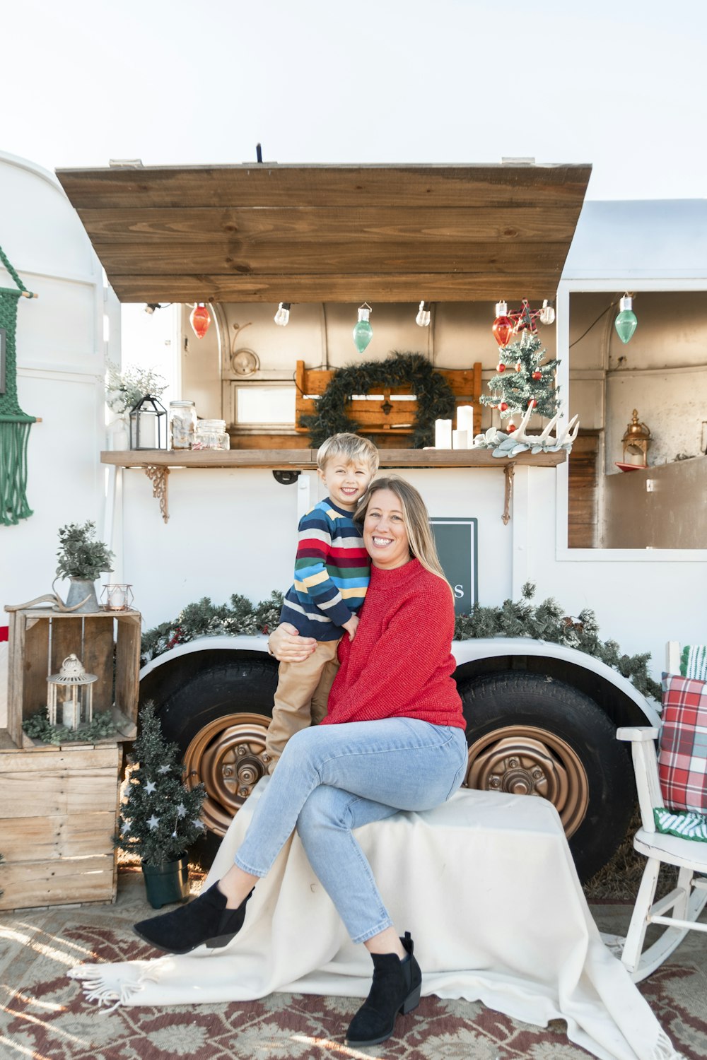 a woman and a boy sitting on a bench in front of a truck