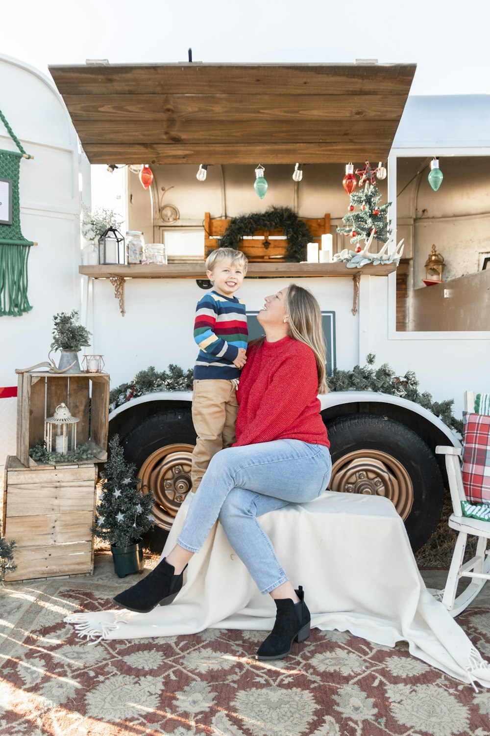 a woman and a boy sitting on a bench in front of a truck