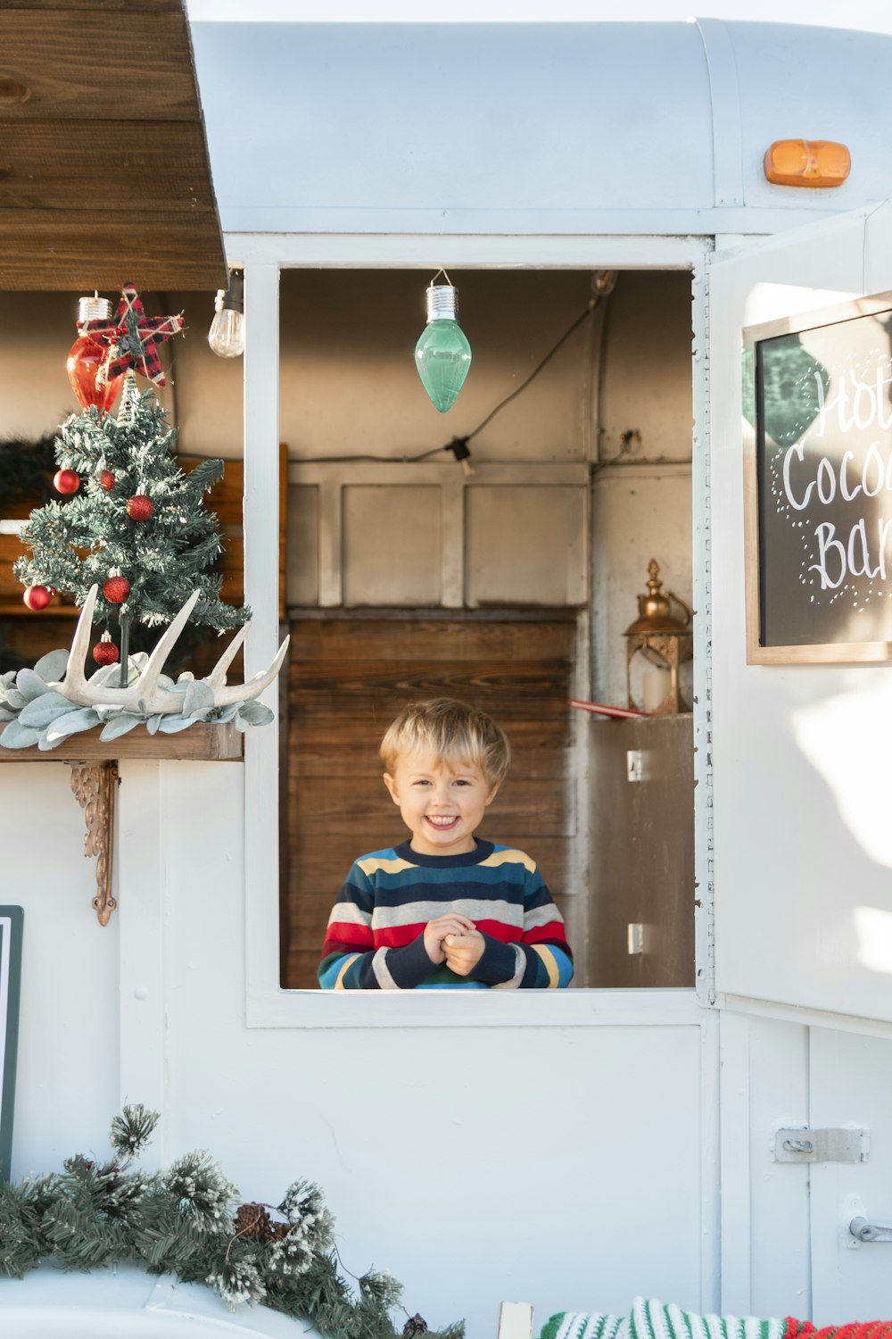 a young boy standing in a window of a food truck