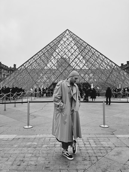 a man standing in front of a large pyramid
