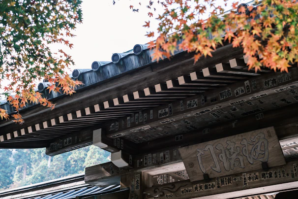 Golden autumn leaves swirling gently around a traditional Bhutanese temple.