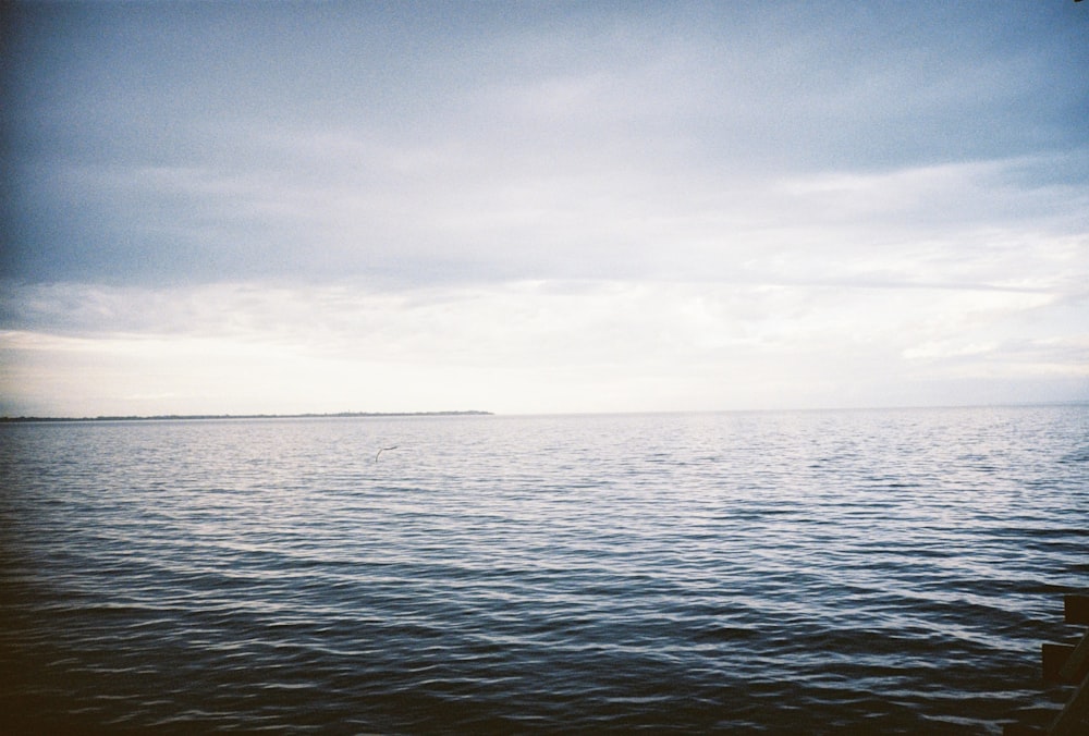 a body of water with a sky in the background