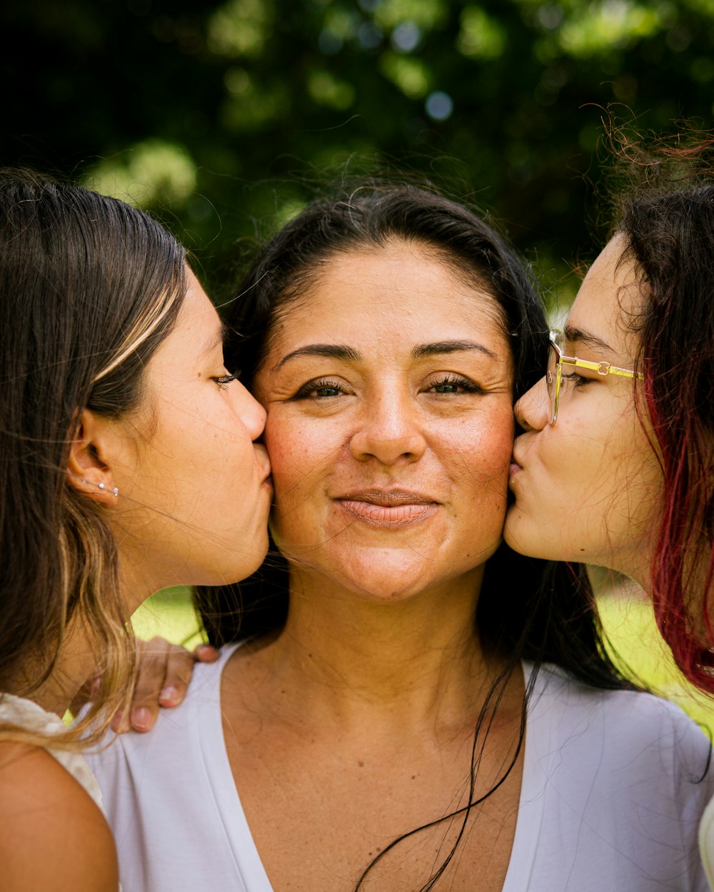 three women kissing each other with their noses close together