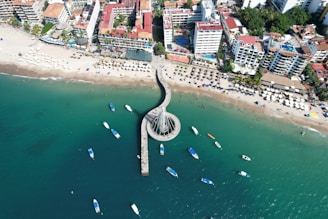 an aerial view of a beach with boats in the water