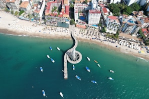 an aerial view of a beach with boats in the water