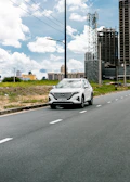 A clean car navigating through downtown Toronto streets on a clear day.