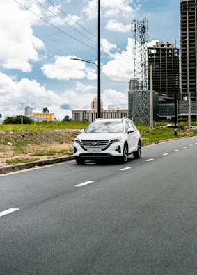 A clean car navigating through downtown Toronto streets on a clear day.