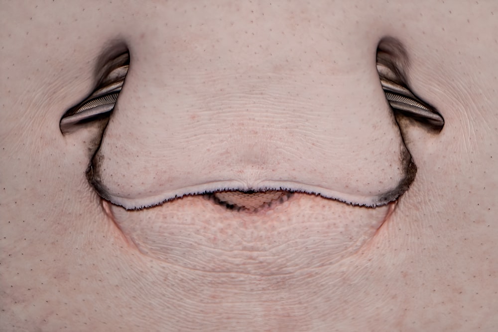 um close up do rosto de uma pessoa com um par de tesouras saindo