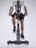 A person dressed in athletic gear is actively pedaling on a stationary exercise bike, with a focus on their lower body and cycling position. The background is minimalistic, highlighting the exercise equipment and individual.