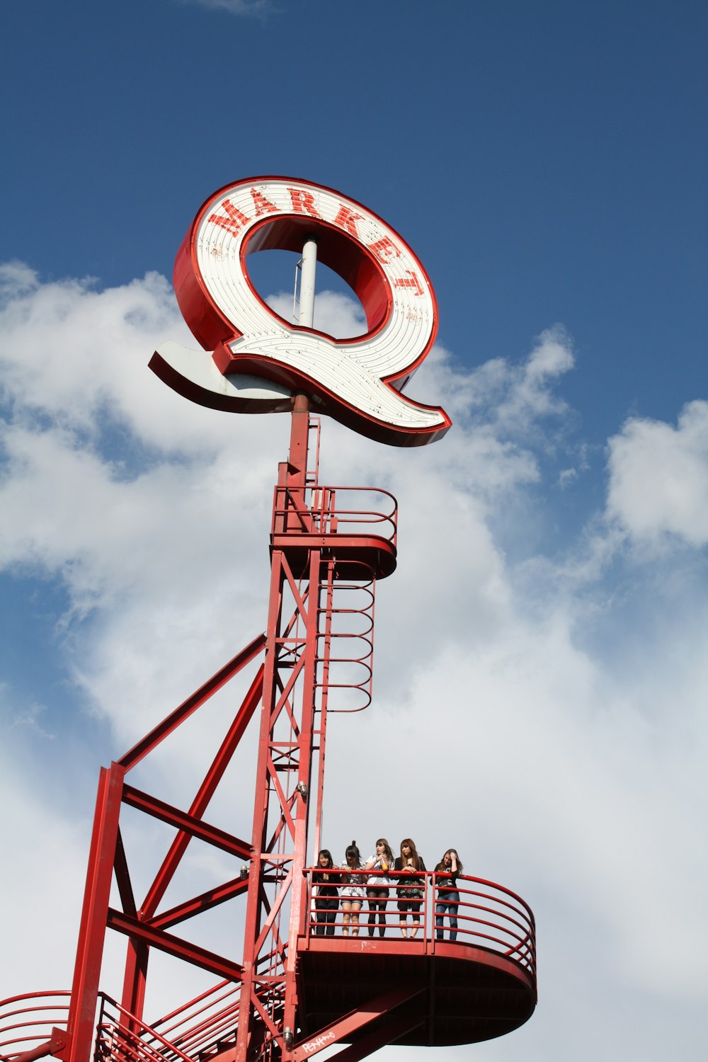 a red and white sign on top of a tower