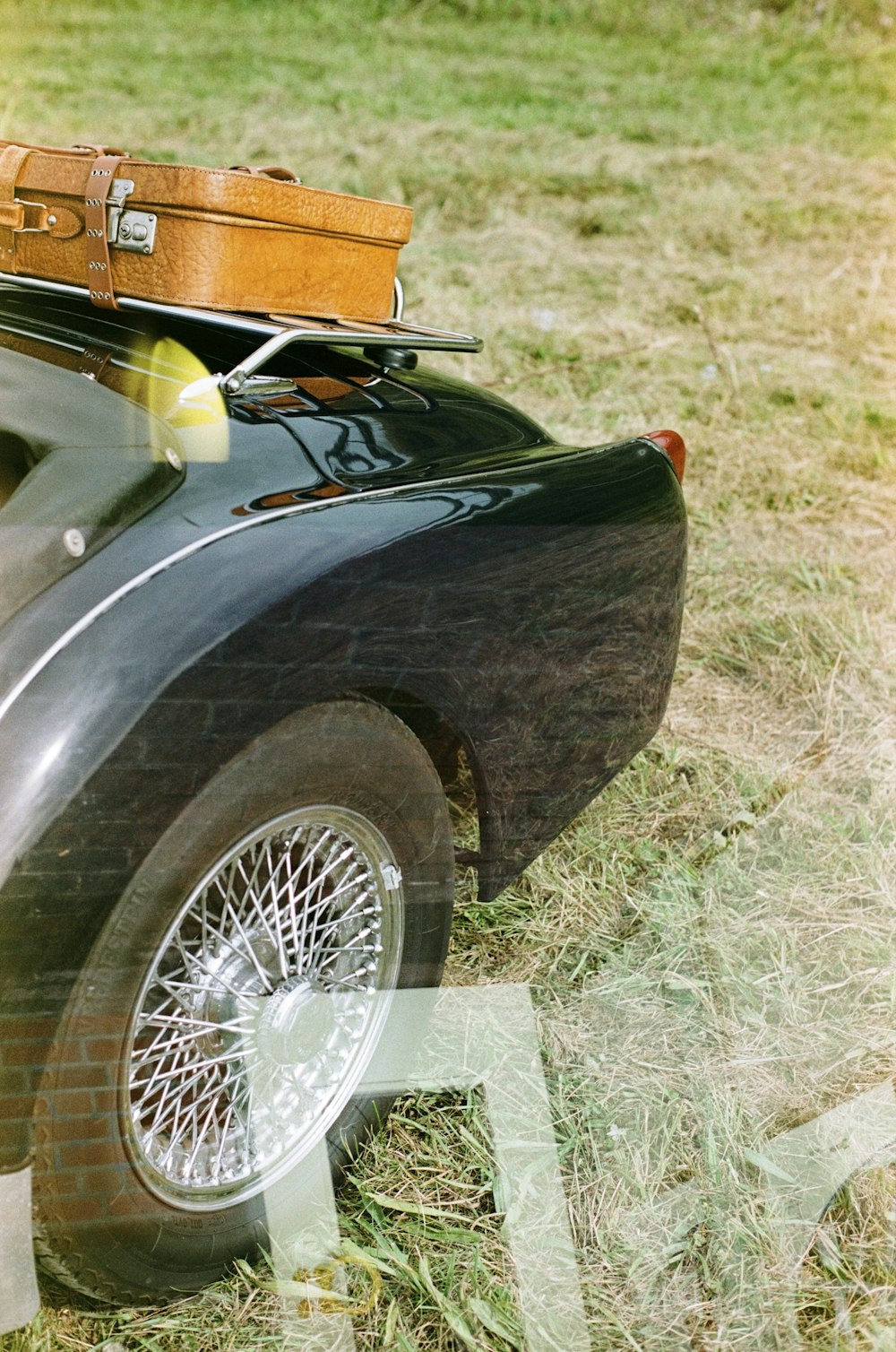 an old car with a suitcase on top of it