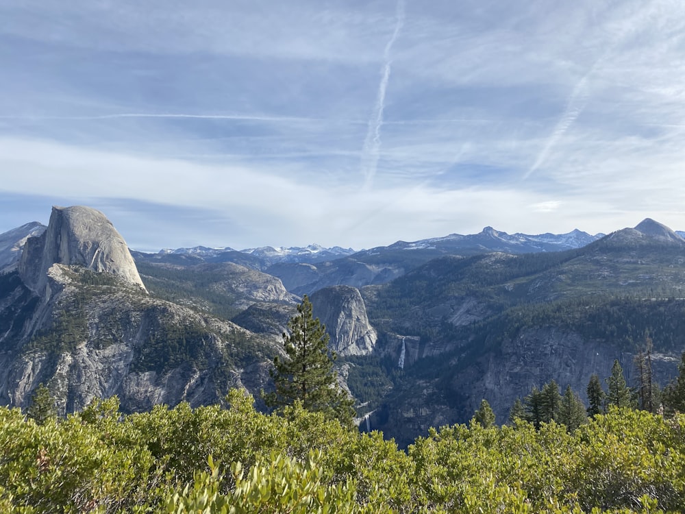 a view of a mountain range with trees and mountains in the background