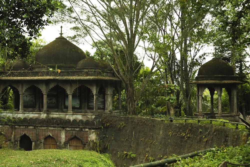 a stone wall with a building in the middle surrounded by trees