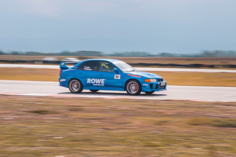 a blue car driving on a race track