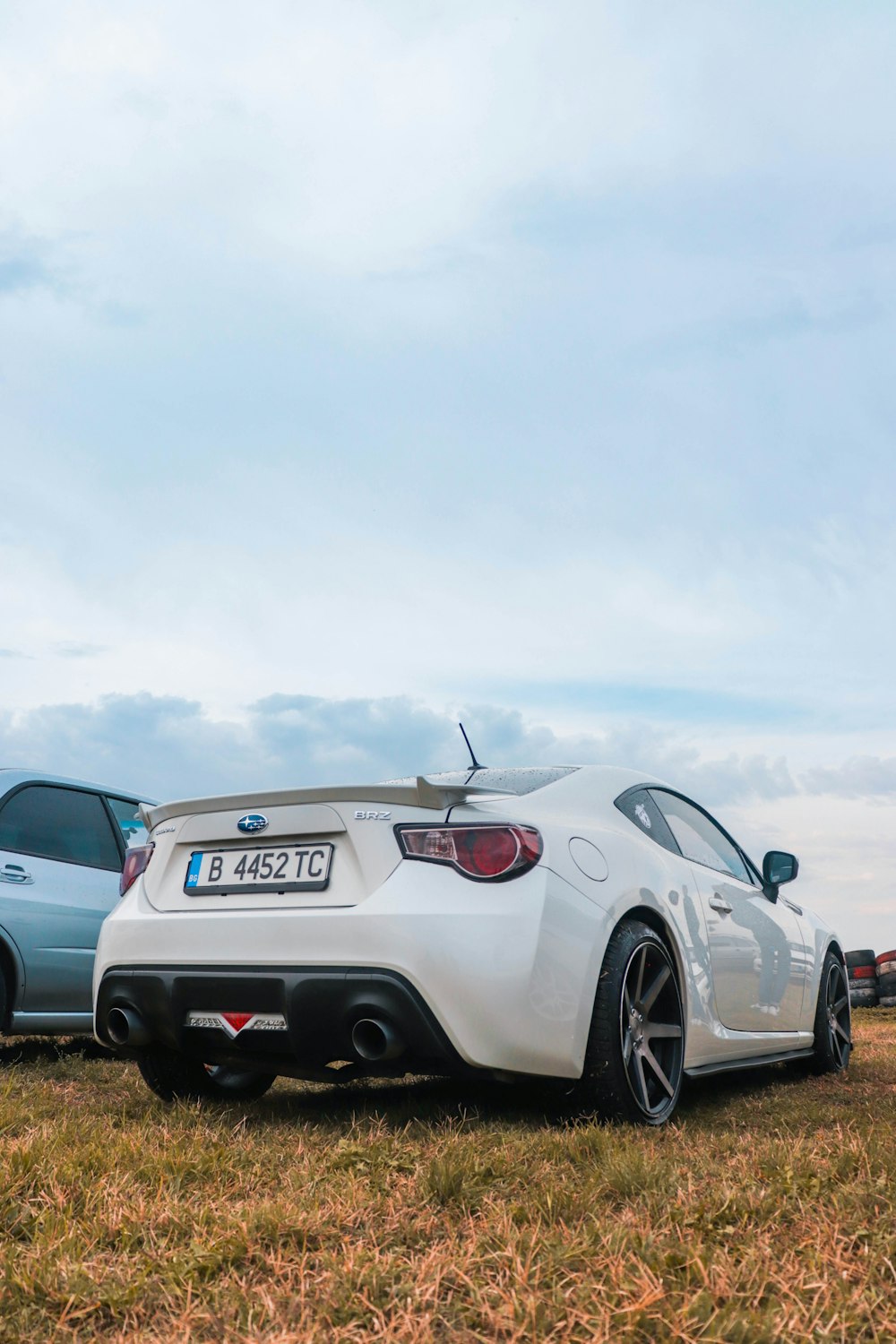 a couple of cars parked next to each other in a field